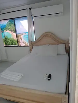 a bed in a room with a window at CABAÑAS CALIPSO, 2 piso in Coveñas