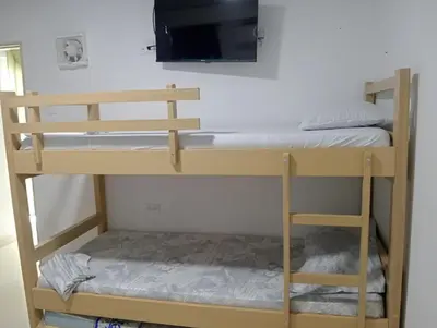 a bunk bed with a flat screen tv on the wall at CABAÑAS CALIPSO, 2 piso in Coveñas