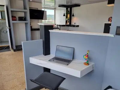 a laptop computer sitting on a white counter with a chair at Studio Apartment Old City Cartagena Almirante in Cartagena de Indias