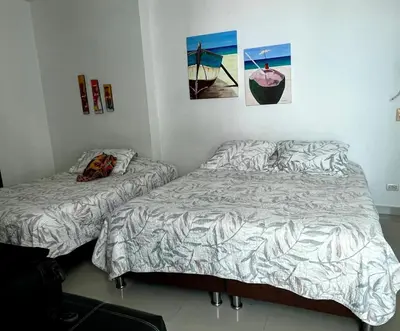 two beds sitting next to each other in a bedroom at Morros Vitri Disfruta de acceso directo a la playa in Cartagena de Indias