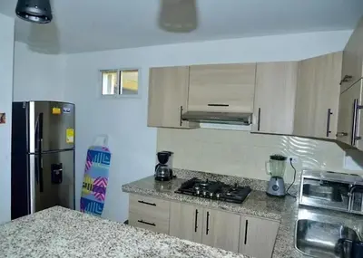 a kitchen with a refrigerator and a counter top at Toscana Suite 3009 in Las Margaritas