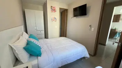 a bedroom with a bed with blue and white pillows at Apto bien ubicado cerca al mar, cerca al centro y al aereopuerto in Cartagena de Indias