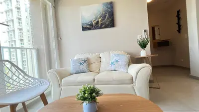 a living room with a white couch and a table at Apto bien ubicado cerca al mar, cerca al centro y al aereopuerto in Cartagena de Indias