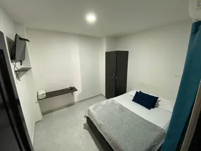 a bedroom with a bed with a blue pillow on it at Hotel Villa Marta Cartagena in Cartagena de Indias