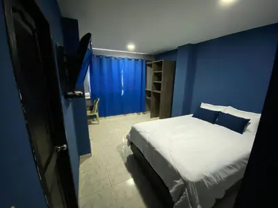 a blue bedroom with a bed and a blue wall at Hotel Villa Marta Cartagena in Cartagena de Indias
