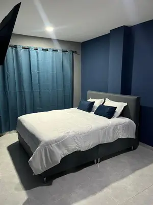 a bedroom with a large bed with blue walls at Hotel Villa Marta Cartagena in Cartagena de Indias