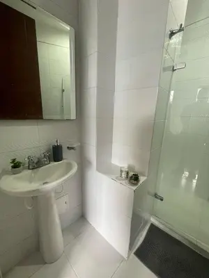 a white bathroom with a sink and a shower at Excelente apartaestudio in Sincelejo