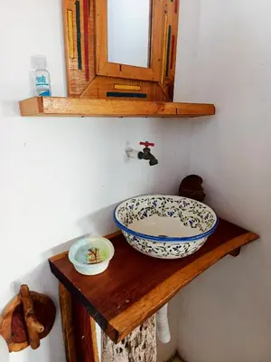 a bathroom with a sink and a mirror on a shelf at Cabaña Alojamiento Valhalla in Rincón