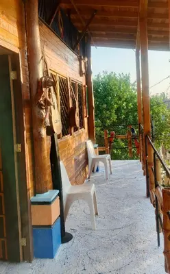 two white chairs sitting on the porch of a house at Cabaña Alojamiento Valhalla in Rincón