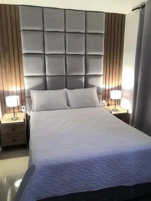 a bedroom with a large white bed with two lamps at Encanto cerca al mar in Cartagena de Indias