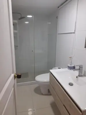 a white bathroom with a shower and a toilet at Apartamento Amoblado in Cartagena de Indias
