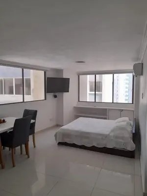 a bedroom with a bed and a table and some windows at Apartamento Amoblado in Cartagena de Indias