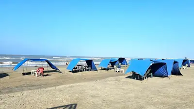 a group of blue tents on the beach at Apartamento cerca a la playa y al mar Punta Roca in Maizal