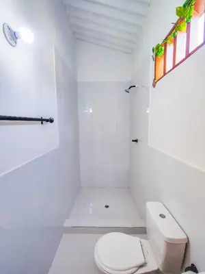 a white bathroom with a toilet and a shower at Casa Blanca Broqueles Hotel in Moñitos