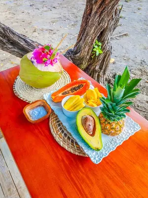 a table with a plate of food and fruits on it at Casa Blanca Broqueles Hotel in Moñitos