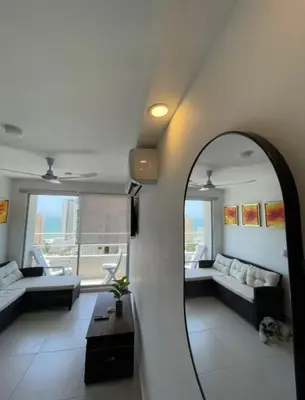 a room with a mirror and a living room with a couch at B lounge experience ctg bolívar in Cartagena de Indias