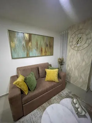 a living room with a brown couch with yellow pillows at Apartaestudio 91 in Barranquilla