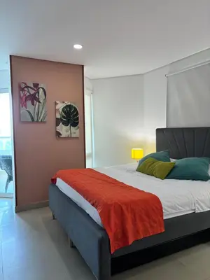 a bedroom with a bed with a red blanket at Ocean and Lagoon View Apartment in Cartagena El Laguito 804A in Cartagena de Indias