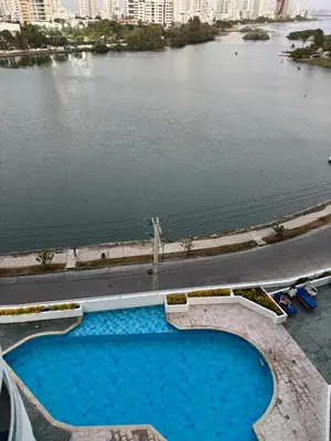 a large swimming pool next to a body of water at Ocean and Lagoon View Apartment in Cartagena El Laguito 804A in Cartagena de Indias