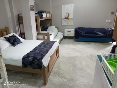 a bedroom with two beds and a blue couch at Terraza Del Sol in Coveñitas