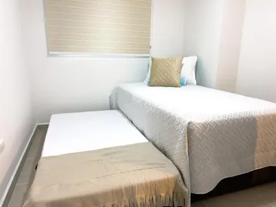 a small bedroom with two beds and a window at Cozy and close to the airport in Cartagena de Indias