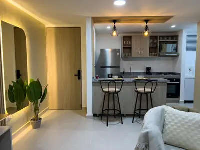 a kitchen with a counter and stools in a room at Cozy and close to the airport in Cartagena de Indias