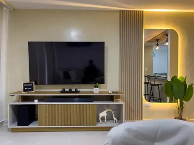 a living room with a television and a cat on a shelf at Cozy and close to the airport in Cartagena de Indias