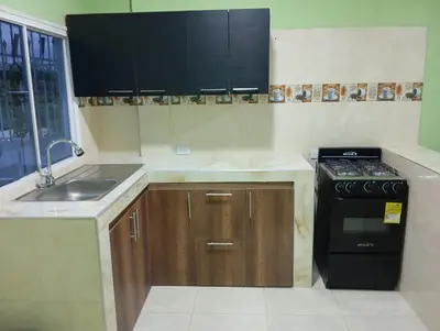 a kitchen with a sink and a stove at Apartamentos el farol in Ciénaga