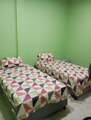 a bedroom with two beds with a quilt on them at Apartamentos el farol in Ciénaga