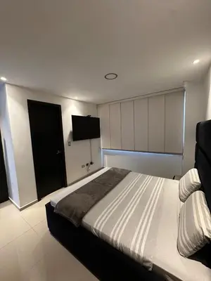 a bedroom with a bed and a flat screen tv at Luxury 14th floor with amazing view in Barranquilla