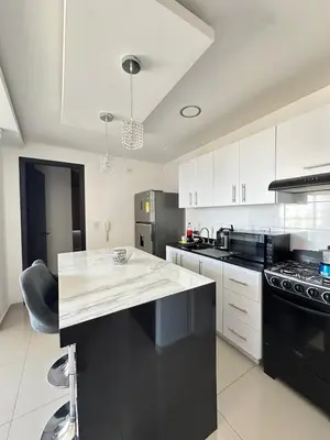 a kitchen with white cabinets and a black appliances at Luxury 14th floor with amazing view in Barranquilla