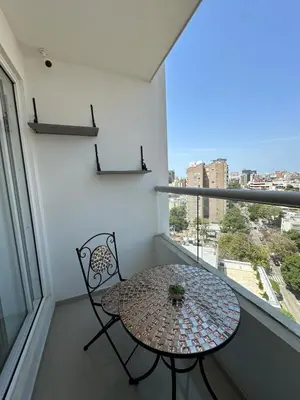 a table and chair on a balcony with a window at Luxury 14th floor with amazing view in Barranquilla