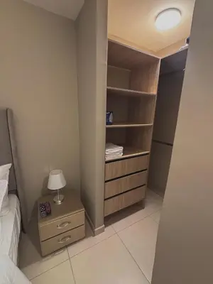 a bedroom with a bed and a night stand with a lamp at Apartment in Alameda del Río in Barranquilla