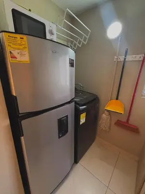a kitchen with a refrigerator and a trash can at Apartment in Alameda del Río in Barranquilla