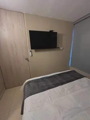 a bedroom with a bed and a flat screen tv on the wall at Apartment in Alameda del Río in Barranquilla