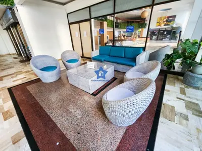 a lobby with wicker chairs and a blue couch at Apartamento Vista Panorámica - Piso 20 in Cartagena de Indias