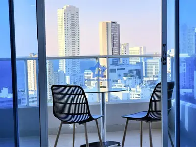 two chairs and a table on a balcony with a city view at Apartamento Vista Panorámica - Piso 20 in Cartagena de Indias