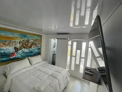 a bedroom with a bed and a painting on the wall at Homethel Studio Apt privado in Cartagena de Indias