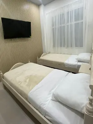 two beds in a room with a tv on a wall at Apartamento en Centro histórico de Cartagena in Estación El Salto