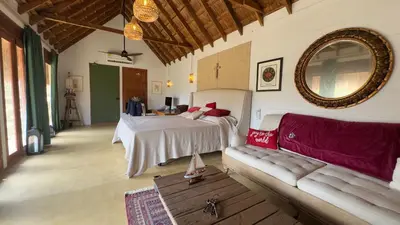 a bedroom with a bed and a couch and a mirror at Hacienda San Benito in Cartagena de Indias