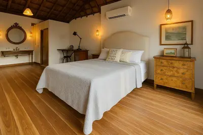 a bedroom with a large white bed and a dresser at Hacienda San Benito in Cartagena de Indias