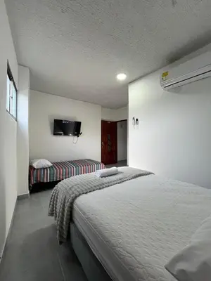 a bedroom with a bed and a tv on the wall at Casa Corales Cartagena in Cartagena de Indias