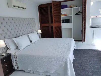 a bedroom with a white bed and a television at Espectaculares Vistas, Edificio Nautilus, Barrio El Laguito. in Cartagena de Indias