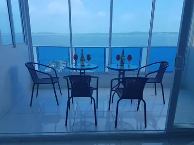 a table and chairs with wine glasses on a balcony at Espectaculares Vistas, Edificio Nautilus, Barrio El Laguito. in Cartagena de Indias