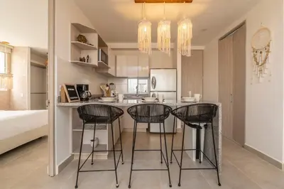a kitchen with three bar stools at a kitchen counter at Apartment with a Pool and Parking 2Bed in Cartagen in Cartagena de Indias