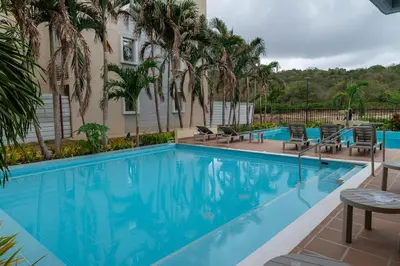 a large swimming pool with chairs and a building at Apartment with a Pool and Parking 2Bed in Cartagen in Cartagena de Indias