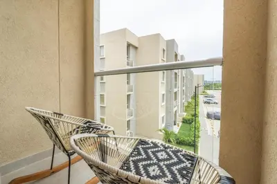 a balcony with a rattan chair and a view of a street at Apartment with a Pool and Parking 2Bed in Cartagen in Cartagena de Indias