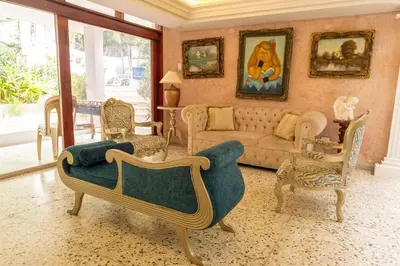 a living room with a couch and some chairs at Casa Gaitán Beach and comfort by the sea in Cartagena de Indias