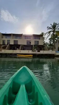 a green kayak in the water in front of a building at Exclusive Loft in Barú, access by sea and land in Isla Barú