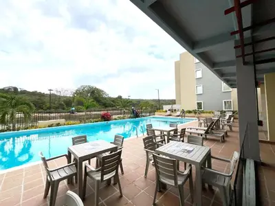 a patio with tables and chairs next to a swimming pool at 
